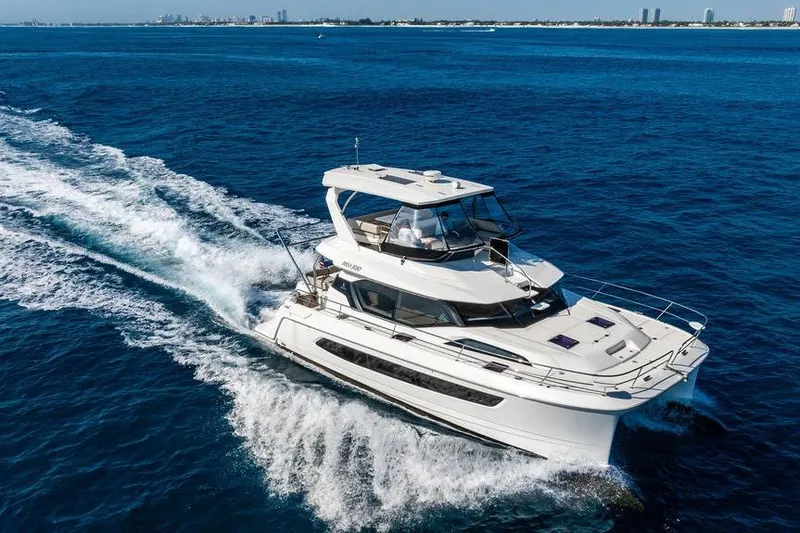 Slide: The Image of 2024 Aquila 44 Yacht cruising on open blue sea, creating a wake. - 20