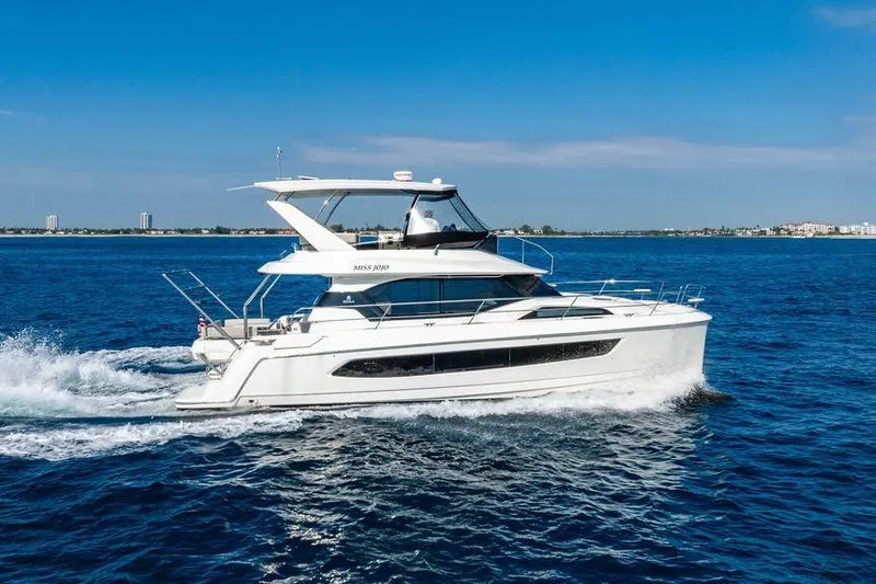 Slide: The Image of 2024 Aquila 44 Yacht cruising on open water under clear blue skies. - 21