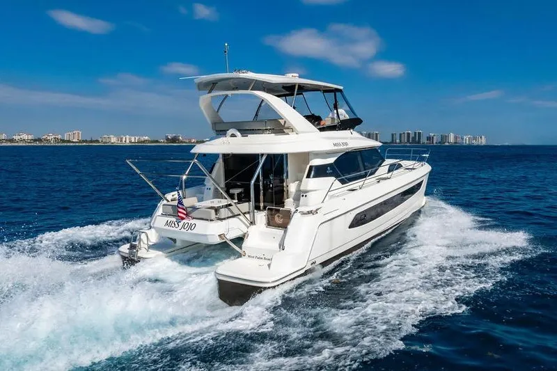 Slide: The Image of 2024 Aquila 44 Yacht cruising on open water under clear blue skies. - 24