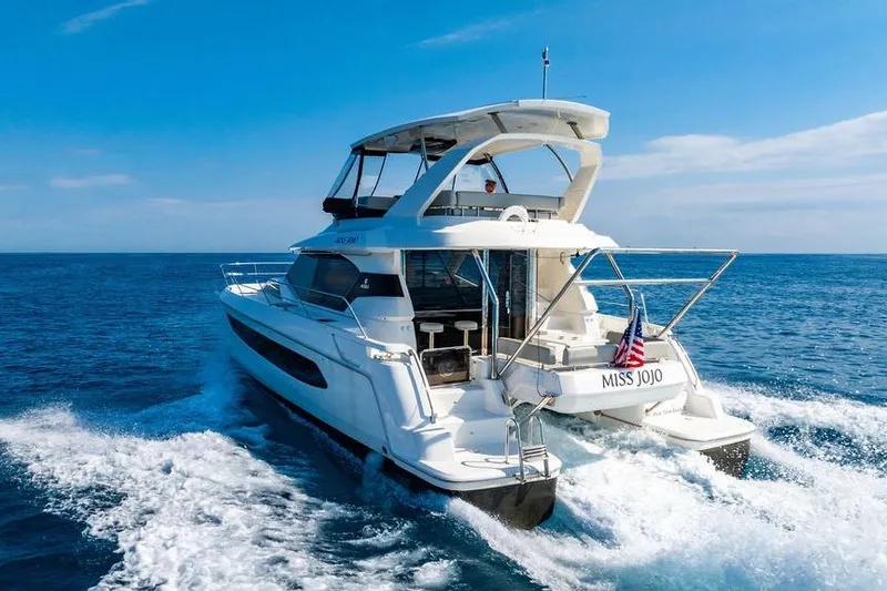 Slide: The Image of 2024 Aquila 44 Yacht cruising on open sea under clear blue sky. - 26