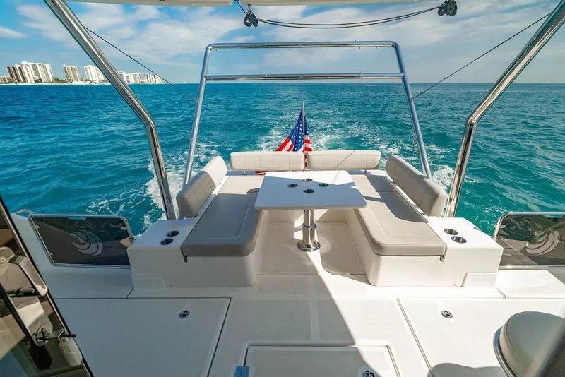 Slide: The Image of 2024 Aquila 44 Yacht cruising on blue ocean with city skyline in background. - 34