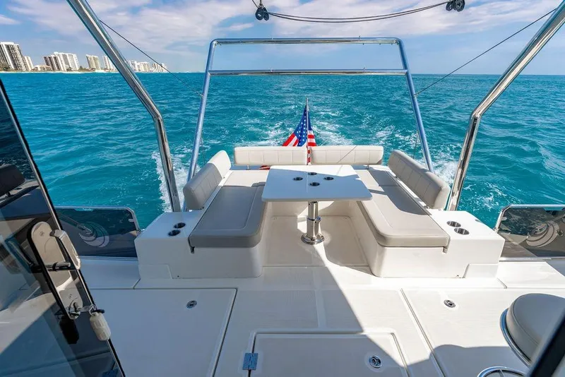 Slide: The Image of 2024 Aquila 44 Yacht cruising on blue ocean with city skyline in background. - 36