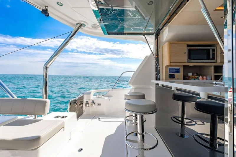 Slide: The Image of Luxurious 2024 Aquila 44 Yacht interior with ocean view, featuring modern seating and kitchenette. - 37