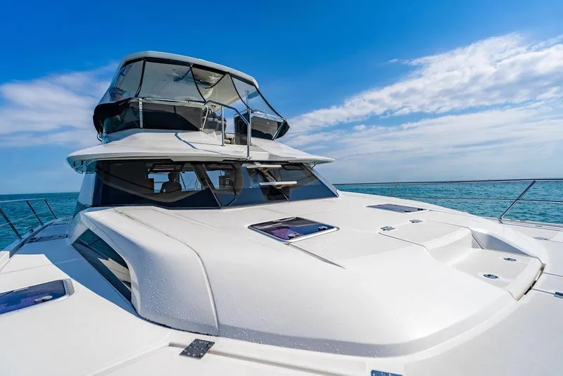 Slide: The Image of 2024 Aquila 44 Yacht cruising on open sea under clear blue sky. - 49