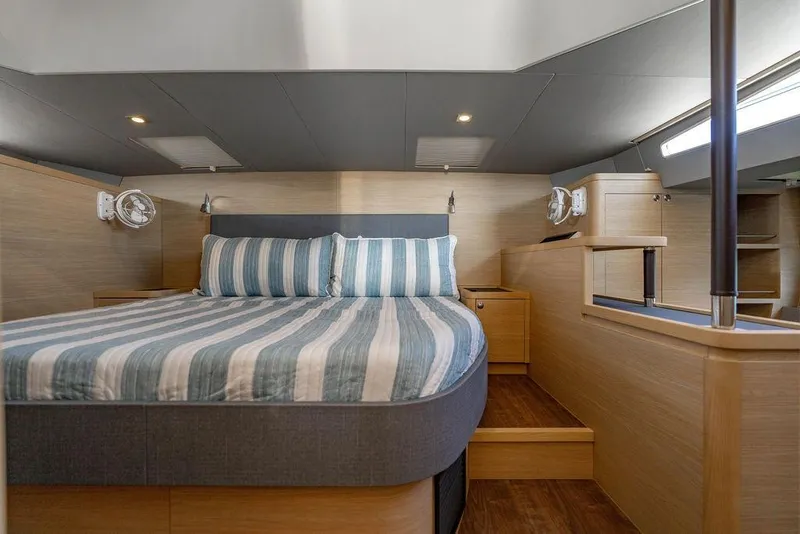 Slide: The Image of Luxurious cabin interior of 2024 Aquila 44 Yacht with striped bedding and modern design. - 65