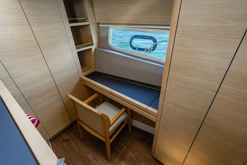 Slide: The Image of 2024 Aquila 44 Yacht interior with wooden desk, chair, and window view. - 68