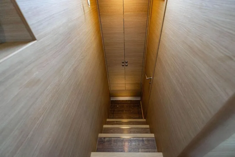 Slide: The Image of Staircase inside 2024 Aquila 44 Yacht, featuring sleek wooden design and modern cabinetry. - 70
