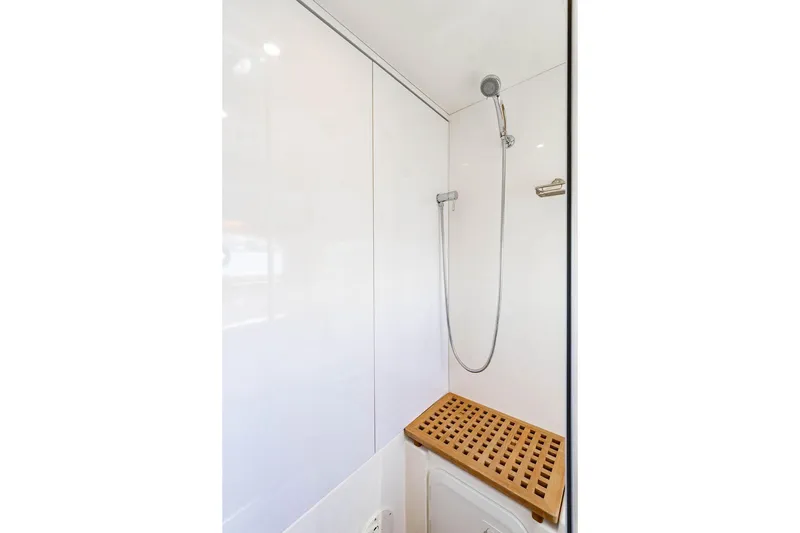 Slide: The Image of Shower area in 2024 Aquila 44 Yacht with wooden bench and modern fixtures. - 85