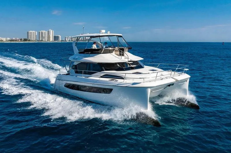 Slide: The Image of 2024 Aquila 44 Yacht cruising on blue ocean near city skyline. - 9