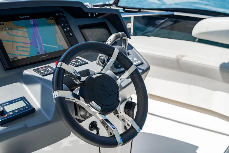 Slide: The Image of Steering wheel and navigation system of 2024 Aquila 44 Yacht cockpit. - 94