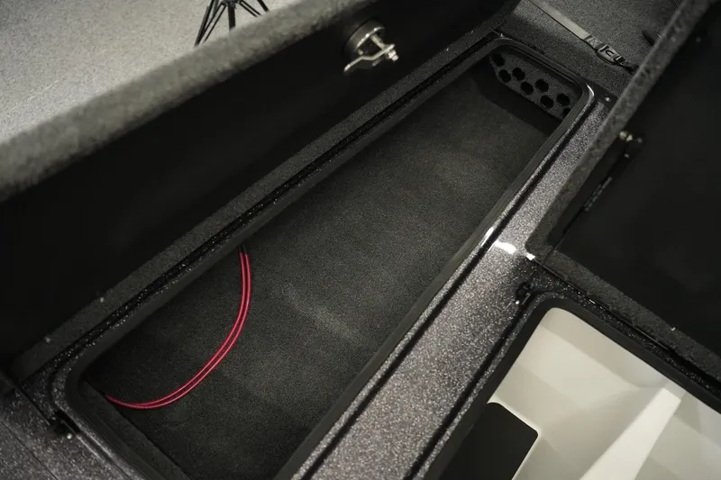 Slide: The Image of Storage compartment of 2026 Bass Cat Puma STS boat, featuring carpeted interior and wiring. - 22