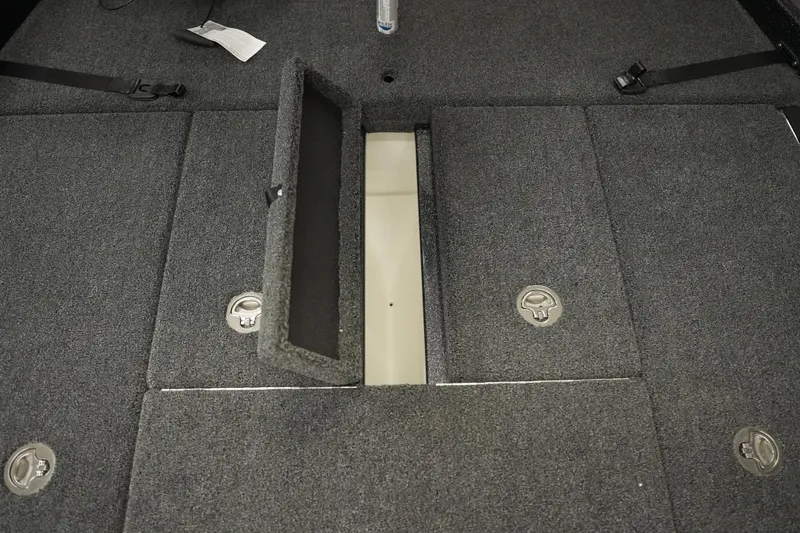 Slide: The Image of Interior storage compartment of 2026 Bass Cat Puma STS boat, featuring carpeted flooring and metal latches. - 24