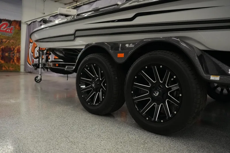 Slide: The Image of 2026 Bass Cat Puma STS boat trailer with sleek black wheels in showroom. - 4