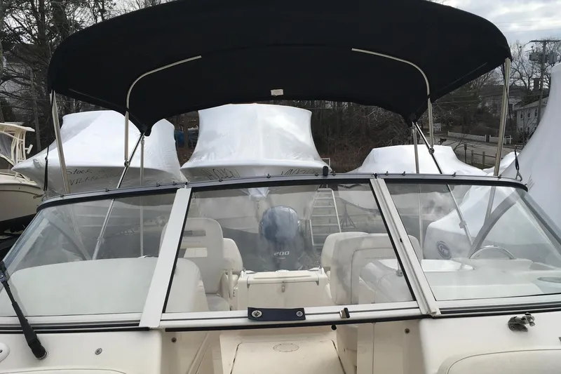 Slide: The Image of 2021 Grady-White Freedom 215 boat with black canopy and windshield, docked outdoors. - 4