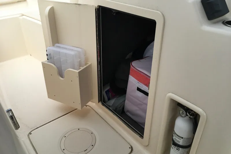 Slide: The Image of Storage compartment on a 2021 Grady-White Freedom 215 boat with fire extinguisher and gear. - 6
