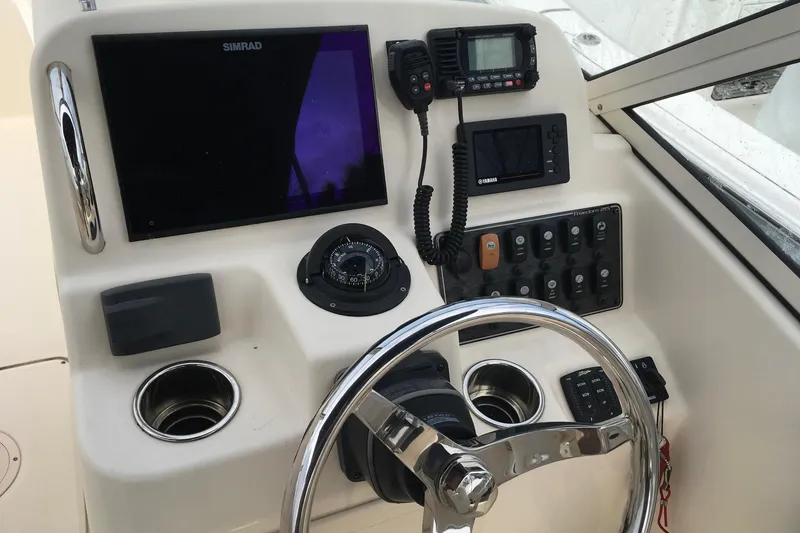 Slide: The Image of 2021 Grady-White Freedom 215 helm with steering wheel, navigation instruments, and control panel. - 7