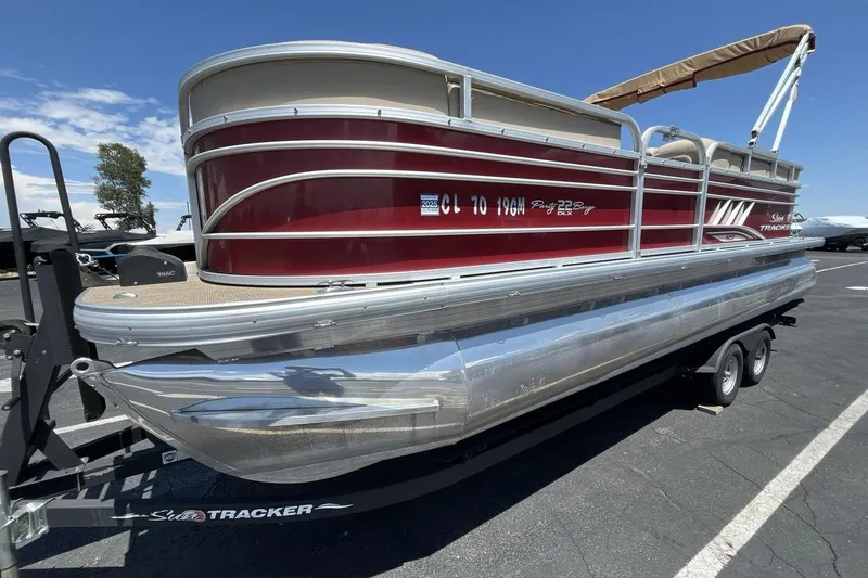 The Image of 2021 Sun Tracker Party Barge 22 XP3 pontoon boat on trailer, parked outdoors. - 1