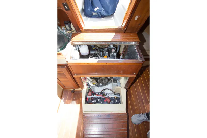 Slide: The Image of Engine compartment of a 1979 Islander Sloop, showcasing mechanical components and wooden interior. - 10