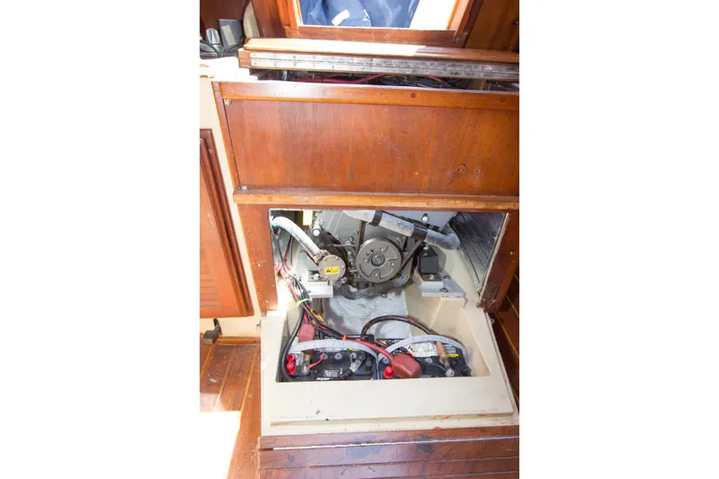 Slide: The Image of Engine compartment of a 1979 Islander Sloop sailboat, showcasing mechanical components and wiring. - 12