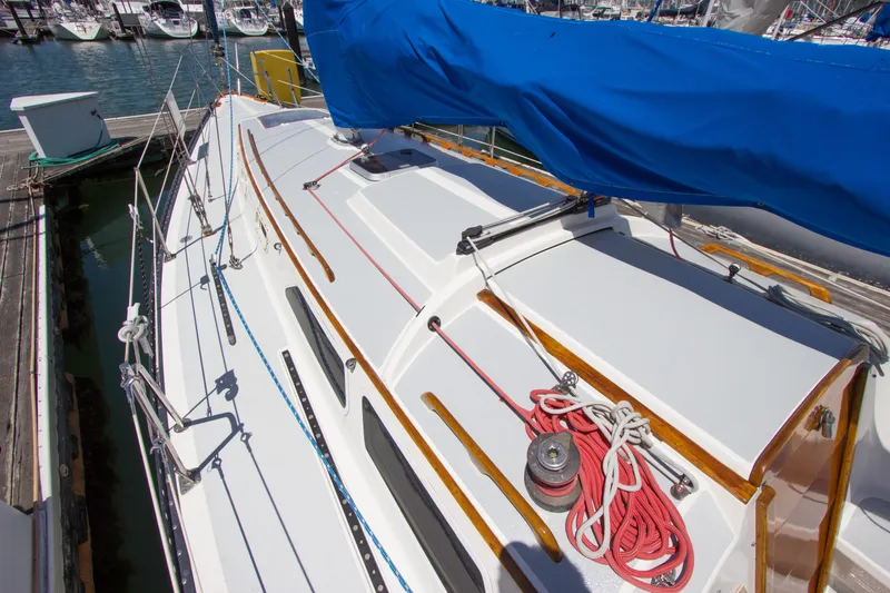 Slide: The Image of 1979 Islander Sloop sailboat with blue sail cover, docked at marina. - 13