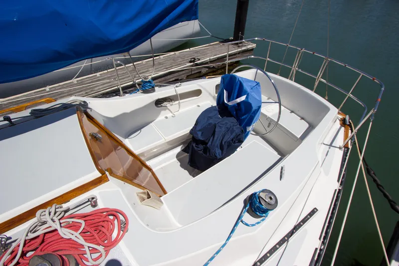 Slide: The Image of 1979 Islander Sloop sailboat cockpit with blue cover and ropes, docked at marina. - 14