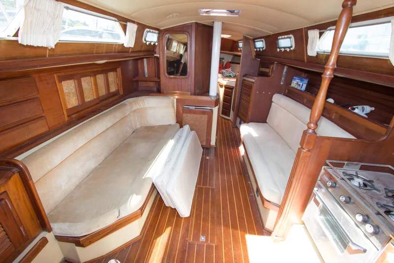 Slide: The Image of Interior of a 1979 Islander Sloop sailboat with wooden furnishings and cozy seating. - 2