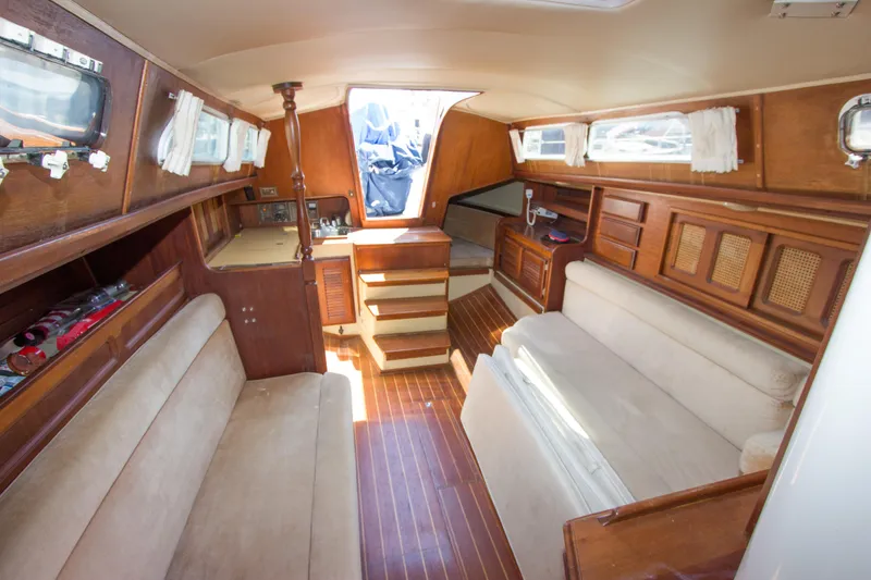 Slide: The Image of Interior of a 1979 Islander Sloop sailboat with wooden furnishings and cozy seating. - 3
