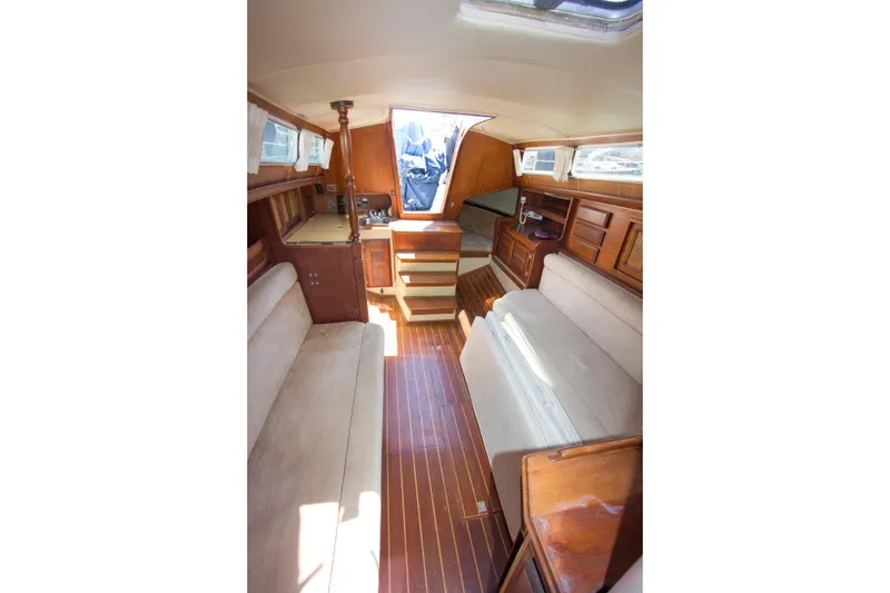 Slide: The Image of Interior of a 1979 Islander Sloop sailboat, featuring wooden finishes and cozy seating. - 4