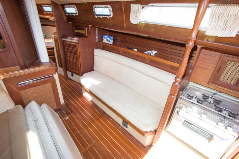 Slide: The Image of Interior of a 1979 Islander Sloop sailboat with wooden finishes and cozy seating. - 5