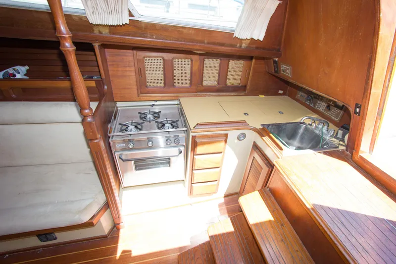 Slide: The Image of Interior of 1979 Islander Sloop with stove, sink, and wooden cabinetry. - 6