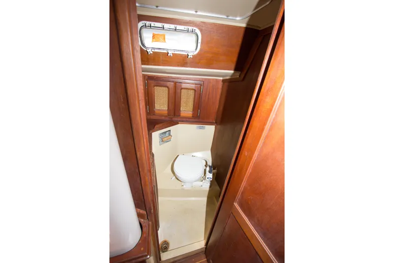 Slide: The Image of 1979 Islander Sloop bathroom interior with wooden cabinetry and compact toilet. - 9