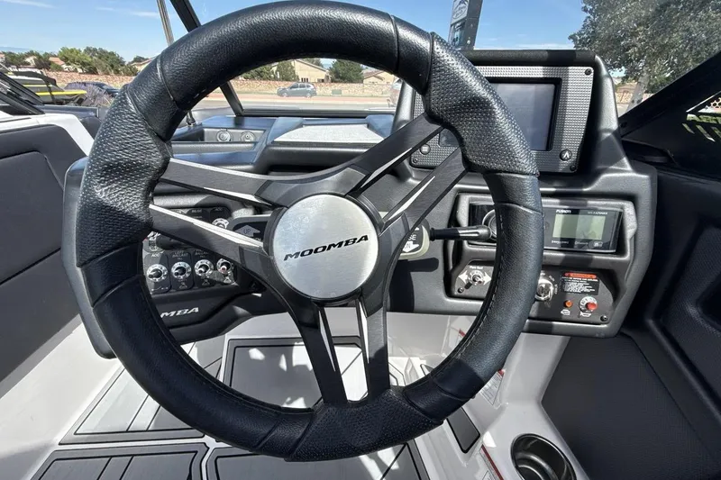 Slide: The Image of 2022 Moomba Makai steering wheel and dashboard controls in a sleek boat interior. - 14