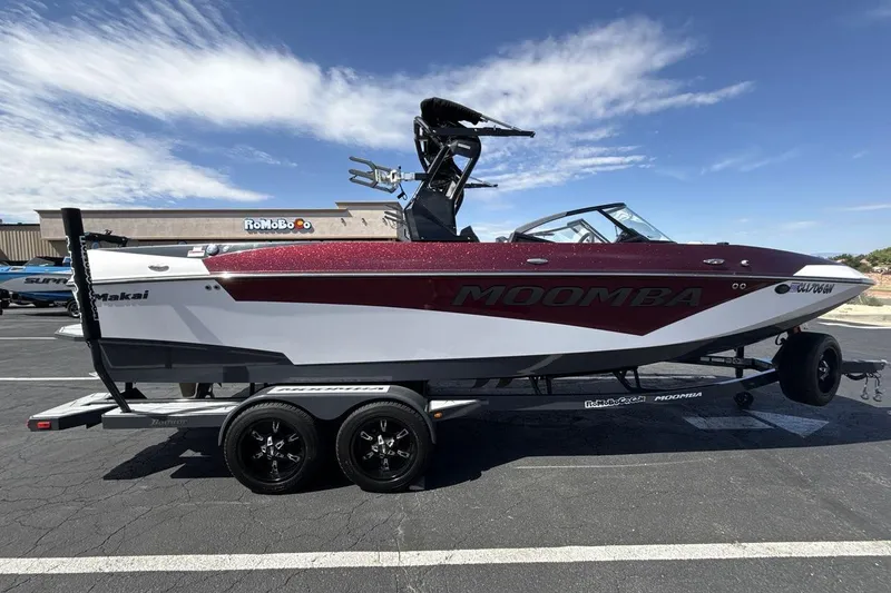 Slide: The Image of 2022 Moomba Makai boat on trailer, parked in a lot under a clear blue sky. - 6