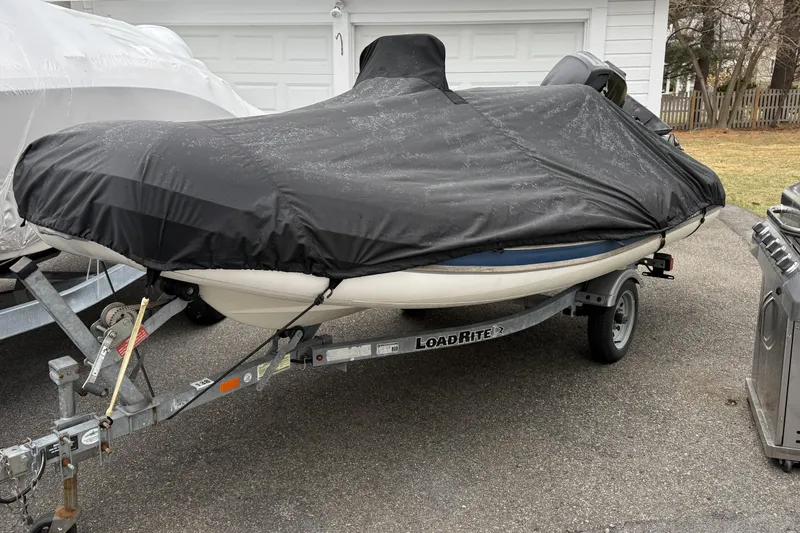 Slide: The Image of Covered 2016 Quicksilver Center Console boat on Load Rite trailer in driveway. - 2