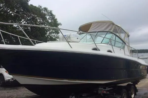 Slide: The Image of 2000 Stamas 310 Express boat on trailer, featuring a sleek design and covered cockpit. - 3