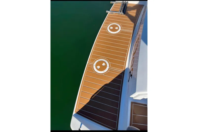 Slide: The Image of Teak deck of 2000 Stamas 310 Express boat, featuring circular hatches. - 5