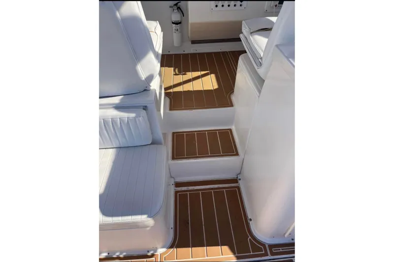 Slide: The Image of Interior view of 2000 Stamas 310 Express boat with white seating and wooden flooring. - 6