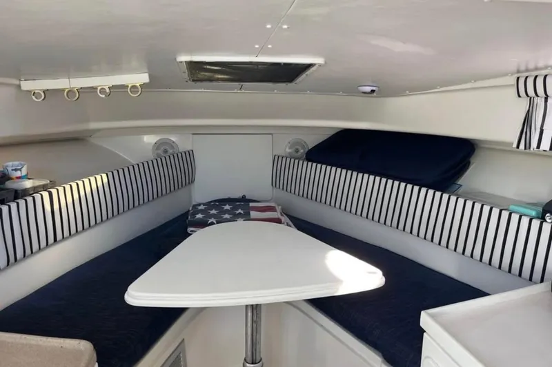 Slide: The Image of Interior cabin of 2000 Stamas 310 Express boat with striped seating and table. - 7