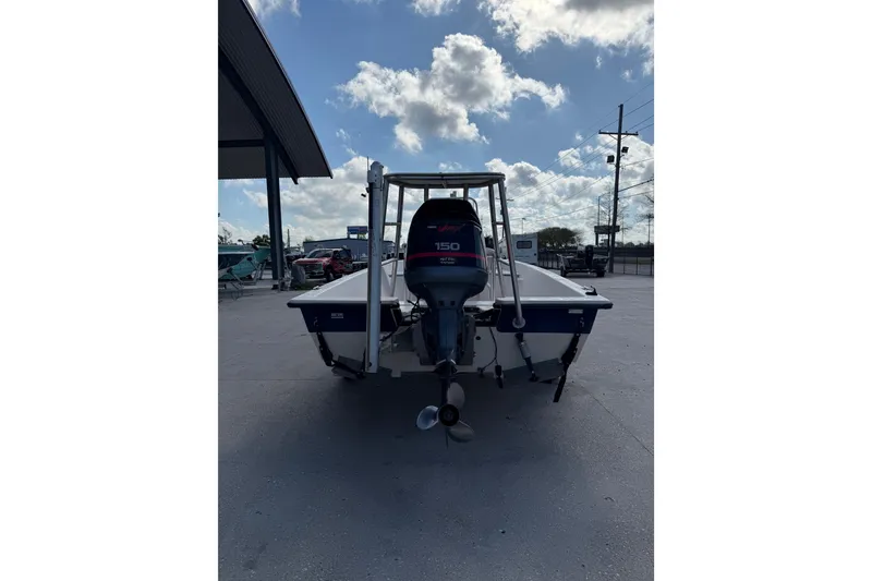 Slide: The Image of 2002 Pathfinder 1900 V boat with Yamaha 150 outboard motor, parked outdoors. - 4