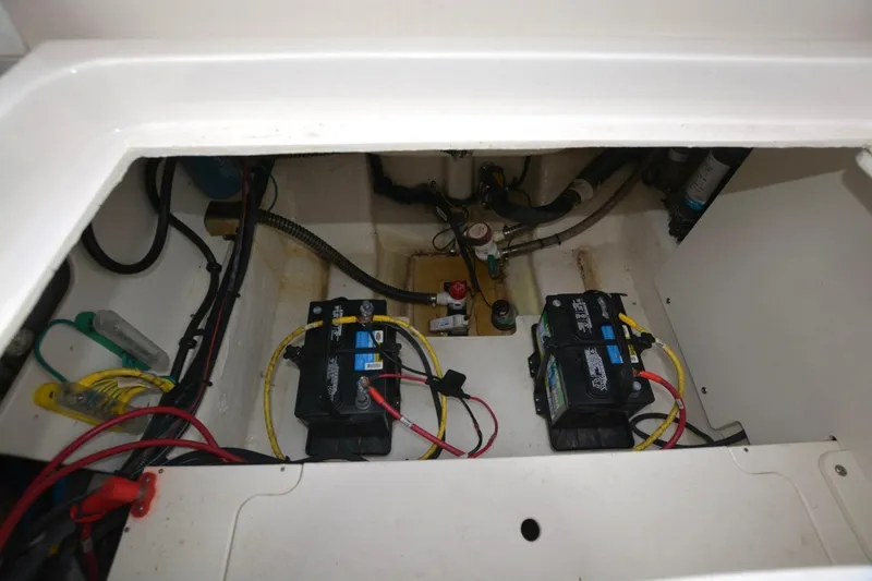 Slide: The Image of 2023 Robalo R230 Center Console boat battery compartment with wiring and components. - 14