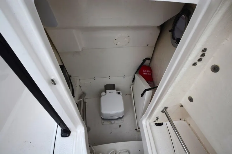 Slide: The Image of 2023 Robalo R230 Center Console boat interior with portable toilet and storage space. - 9