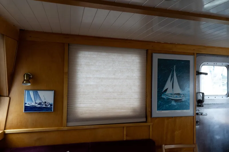 Slide: The Image of Interior of a 1997 Custom Steel Trawler with nautical-themed artwork and wooden paneling. - 12