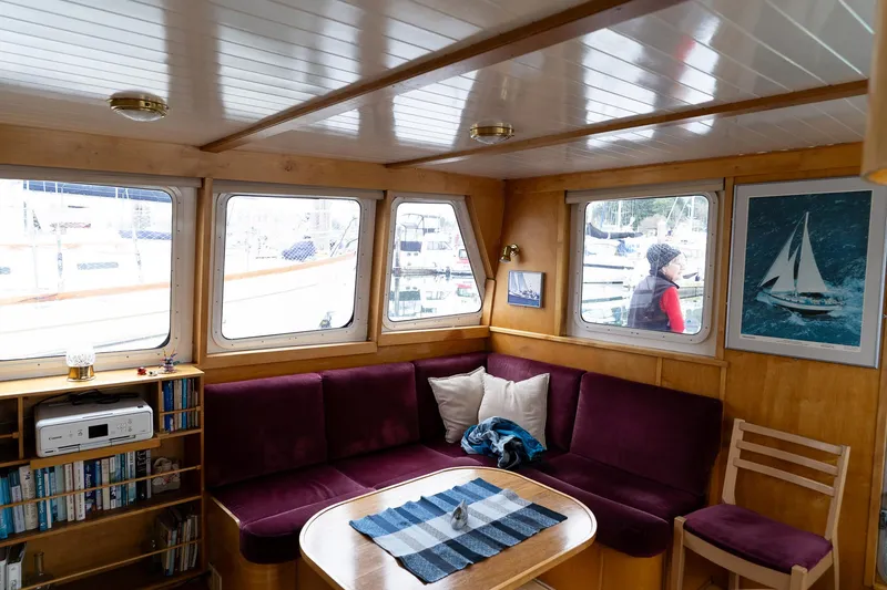 Slide: The Image of Cozy interior of a 1997 Custom Steel Trawler with purple seating and nautical decor. - 13