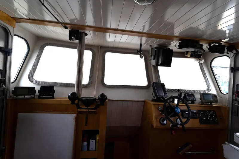 Slide: The Image of Interior of a 1997 Custom Steel Trawler with navigation equipment and steering wheel. - 23