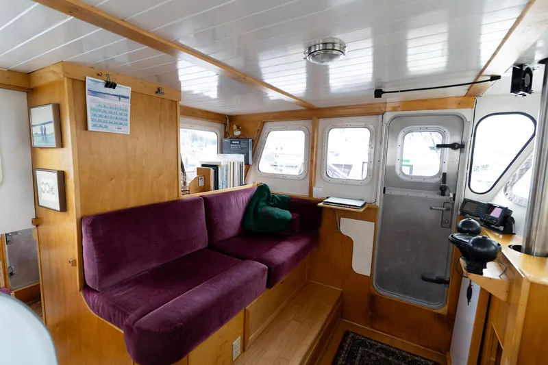 Slide: The Image of Interior of a 1997 Custom Steel Trawler with purple seating and wooden accents. - 25