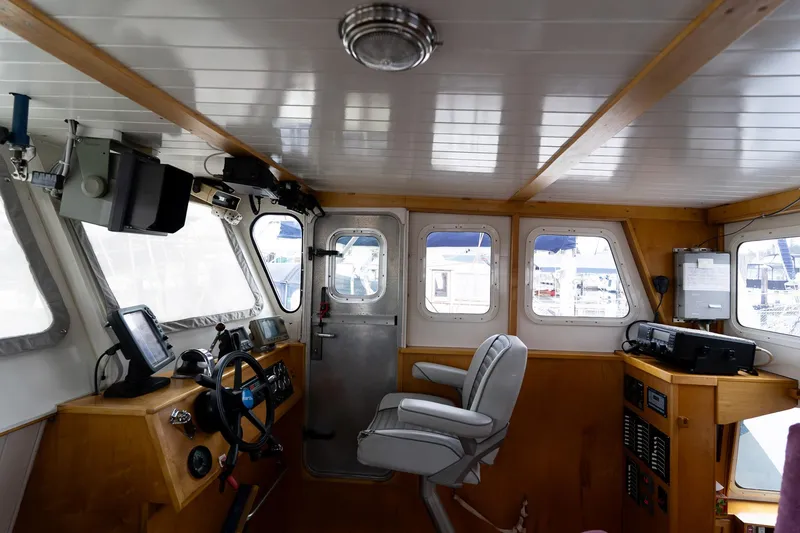 Slide: The Image of Interior of a 1997 Custom Steel Trawler with navigation equipment and captain's chair. - 26