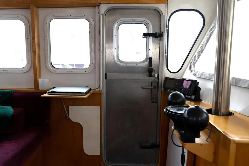 Slide: The Image of Interior of a 1997 Custom Steel Trawler with navigation equipment and seating area. - 28
