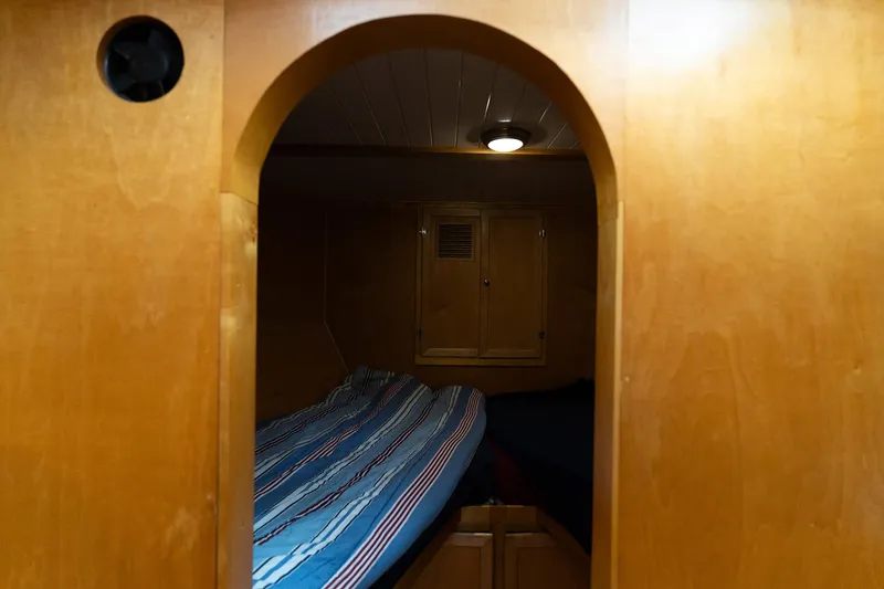 Slide: The Image of Cozy cabin interior of a 1997 Custom Steel Trawler with wooden finish and striped bedding. - 30