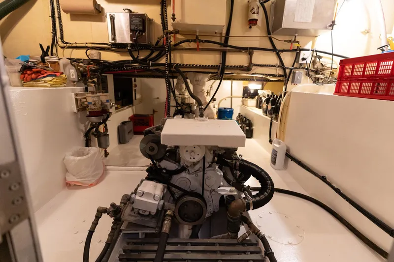 Slide: The Image of Engine room of a 1997 Custom Steel Trawler, showcasing machinery and organized wiring. - 36