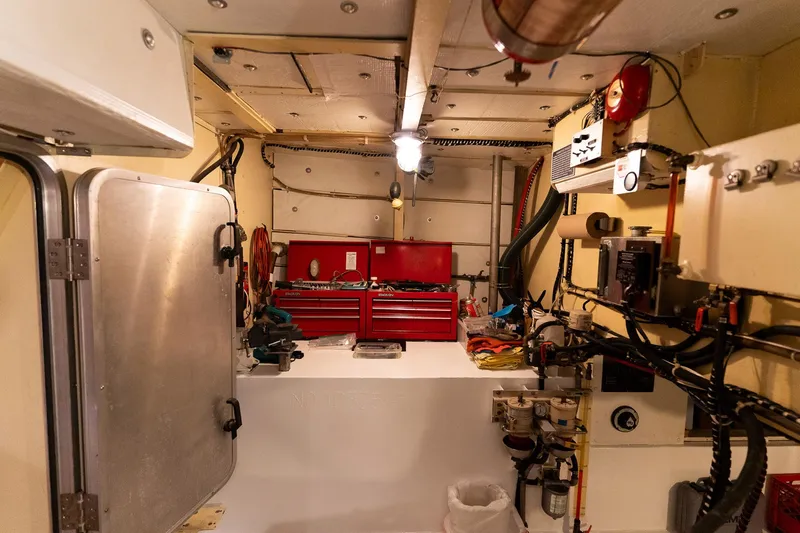 Slide: The Image of Engine room of a 1997 Custom Steel Trawler with toolboxes and equipment. - 40